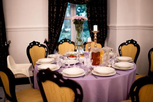 切申Kasztanowy Dwór的一张带盘子和玻璃杯的紫色桌子