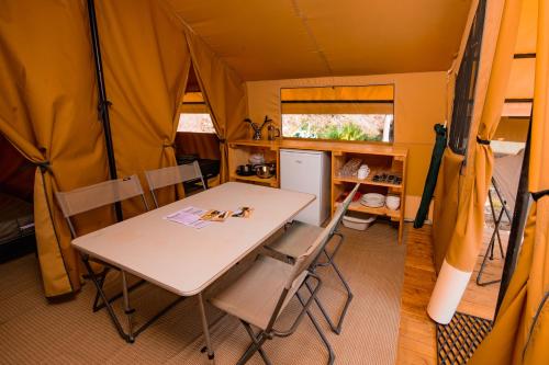 勒瓦德约尔Onlycamp L'Orée des Vosges的帐篷内的用餐室配有桌椅