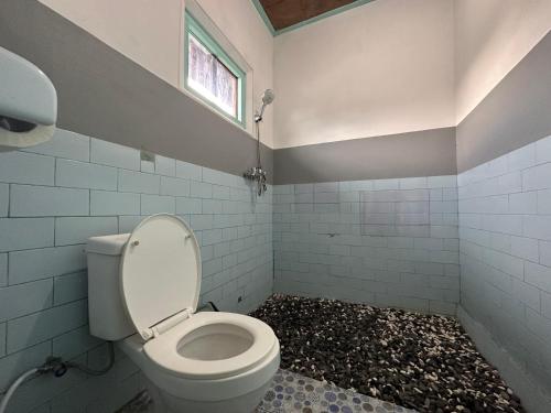 库布盼洛坎Gill Lake Batur的一间带白色卫生间的浴室和窗户。