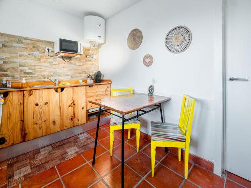 巴雷鲁VILA NATURA的厨房配有木桌和黄色椅子