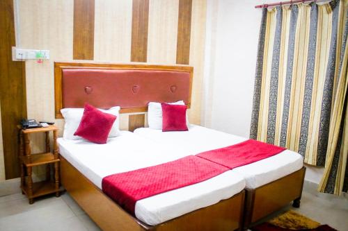 尼泊尔根杰Hotel Pahuna Ghar的一间卧室配有一张带红色枕头的大床
