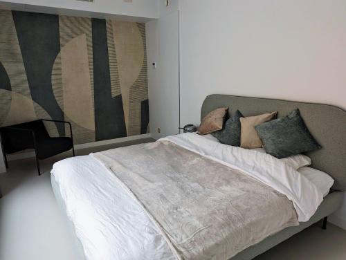 安特卫普Spacious and cosy apartment near Berchem Station的卧室配有一张床,墙上挂有绘画作品