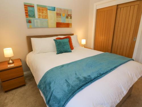 谢菲尔德Causeway Hideaway的一间卧室配有一张带蓝色毯子的床