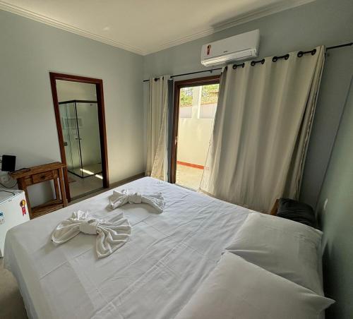 圣若昂-达巴拉Pousada Ribeirinha的卧室配有白色的床和镜子