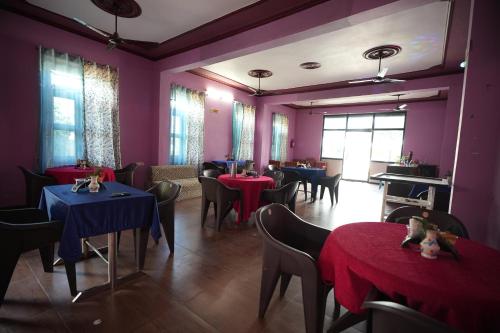 Kota BāghHill crest Kb Restaurant banquet的一间设有桌椅和紫色墙壁的用餐室