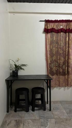 碧瑶Huddle Pad的一张带两张凳子和窗帘的黑桌