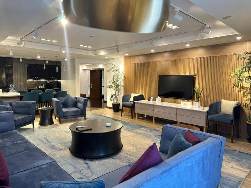 布尔班布尔班珍珠洲际酒店的大堂配有蓝色的家具和平面电视。