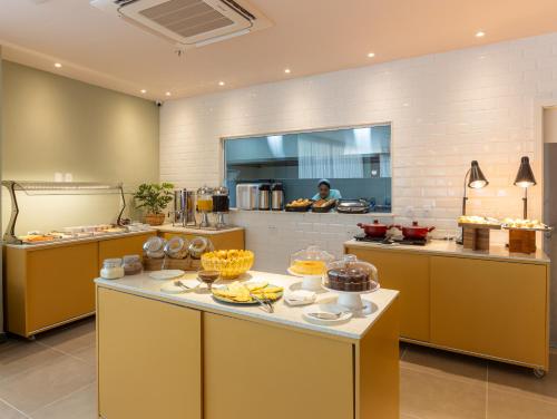里约热内卢B&B HOTEL Santos Dumont的厨房提供自助餐,餐桌上供应食物