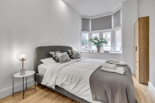 伦敦Lovely Kensington Apartments的一间卧室设有一张大床和一个窗户。