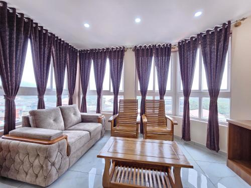 马迪凯里Navarathna Comforts的客厅配有紫色窗帘、沙发和椅子