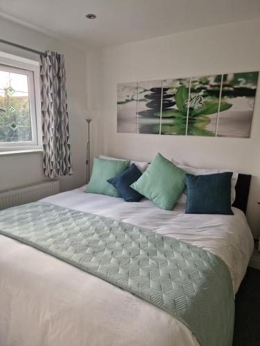 曼彻斯特Posyrooms的卧室配有带蓝色枕头的大型白色床