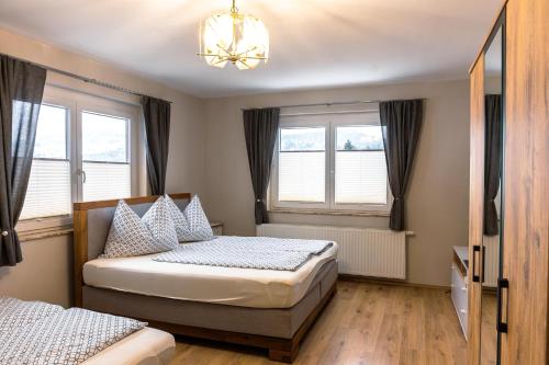 滨湖科伊查赫Real Top 1的卧室设有两张床,配有窗户和吊灯。