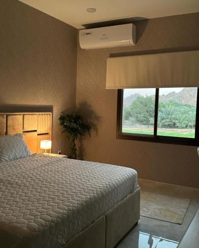 Alhara Lodge استراحة الحارة的一间卧室设有一张大床和一个窗户。