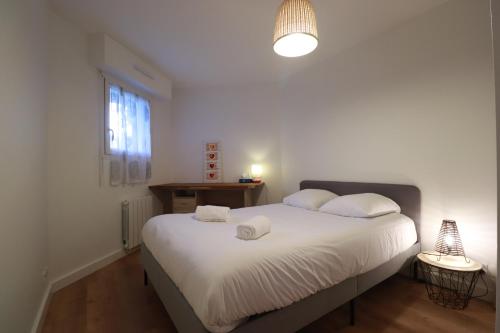 瓦讷Olivia - T2 - confort - wifi- parking的一间卧室配有一张床,上面有两条毛巾