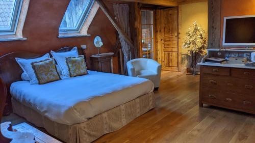 Zimmersheim麦森阿特格尔酒店的一间卧室配有一张床、一张书桌和一台电视