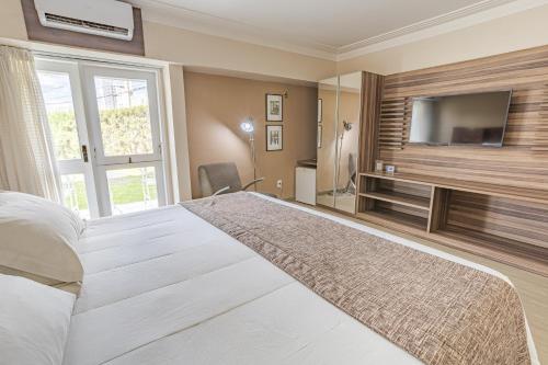 大坎皮纳坎皮纳高级豪华村庄酒店的一间卧室设有一张大床和一台平面电视。