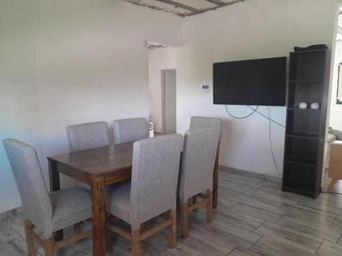 科尔多瓦Alquiler temporario villa allende的用餐室配有桌椅和平面电视。
