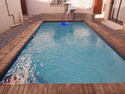 维多利亚瀑布Pillacol Guest House的蓝色房子中的游泳池