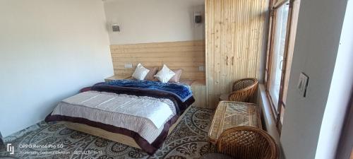 乔斯希马特swayambhu homestay的一间卧室配有一张床和两张藤椅