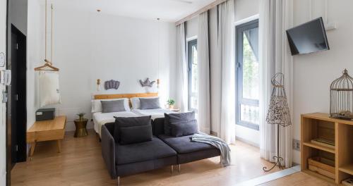 大加那利岛拉斯帕尔马斯Bed and Chic的一间卧室配有一张床、一张沙发和一台电视。