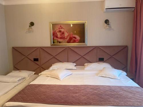 科利比塔Hotel Roser House Boutique - pe malul lacului Colibita的卧室配有2张带白色枕头的大床