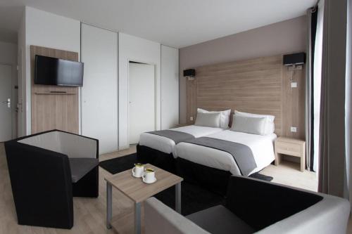 阿斯克新城Twenty Business Flats Lille Grand Stade的酒店客房,配有床和电视
