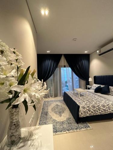 马斯喀特Sifah Ocean Breeze Villa的一间卧室配有床和白色花瓶