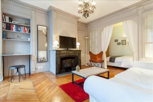 里昂Colombe - Location T2 - Lyon 2的客厅设有一张床和一个壁炉
