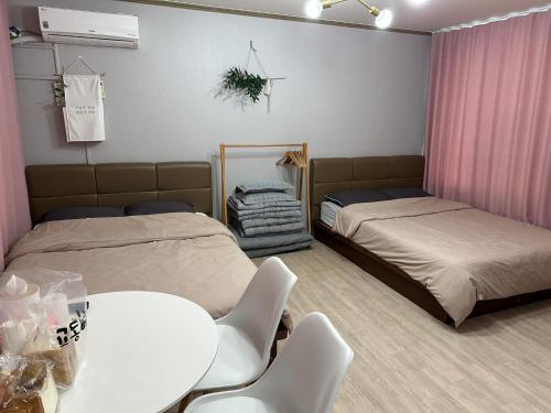 江陵市Sacheon Songlim的配有两张床铺的客房配有桌椅