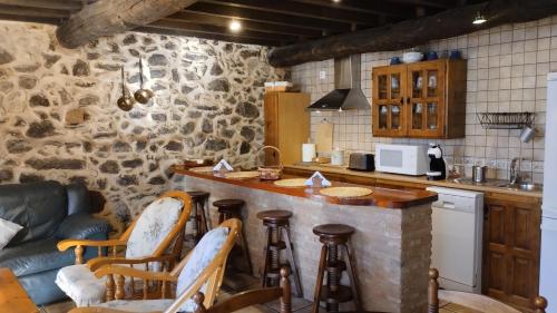 坎德拉里奥Hotel La Casa Chacinera的厨房设有带凳子和沙发的酒吧