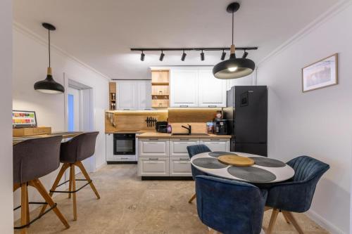 蒂米什瓦拉Five Stars Apartment的厨房配有桌椅和冰箱。