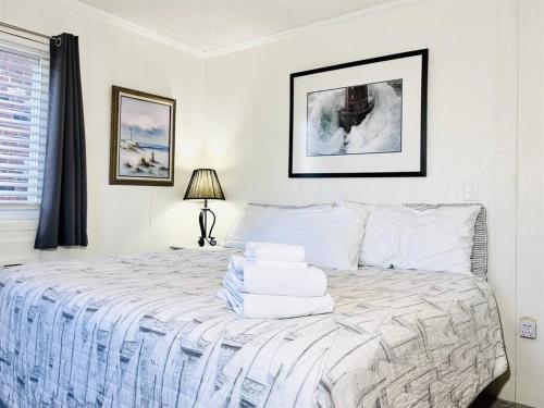 大洋城Stunning 2BR/2BA Bayfront Retreat的白色卧室,配有带毛巾的床