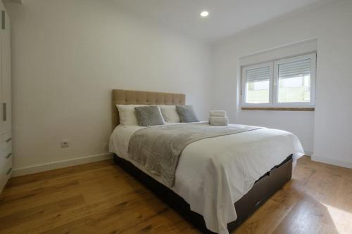 克卢什Apartamento T3 em Lisboa/ Queluz的一间白色客房内配有一张大床的卧室