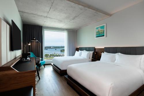 蒙特利尔Hyatt Centric Montreal的酒店客房设有两张床和窗户。