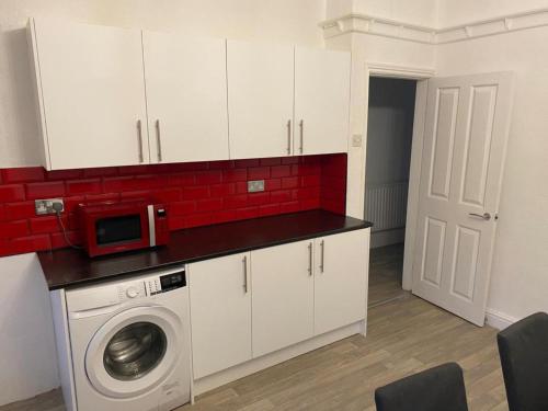 利兹Spacious 4 Bedroom Townhouse的厨房配有洗衣机和微波炉。