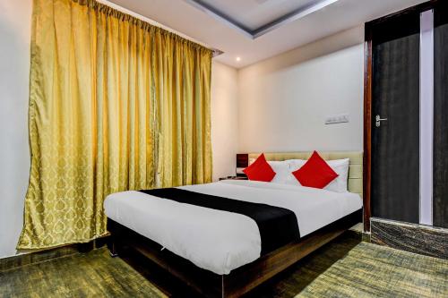 Keonjhargarhhotel adhunik palace的一间卧室配有一张带红色枕头的大床