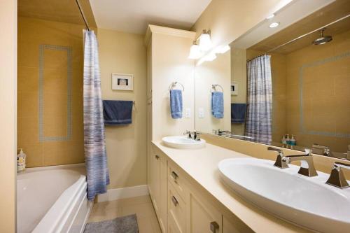 温哥华Vine & Balsam的浴室设有2个水槽、浴缸和镜子