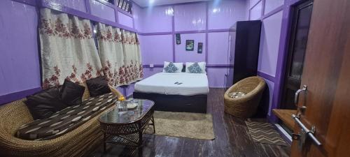 西隆Bloom inn的紫色的客房配有一张床和一张沙发