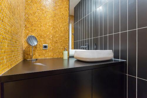 里昂Stella - 2 chambres-balcon- place de la République的浴室设有黑色柜台上的白色水槽