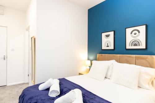 奥尔德姆Suite 4 - Trendy Spot in Oldham City Centre的一间卧室设有蓝色墙和一张床