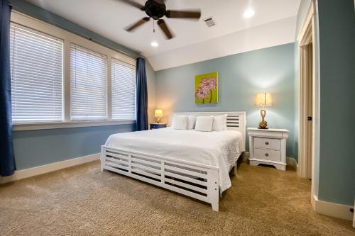 德斯坦Barefoot Bungalo的卧室配有白色的床和吊扇