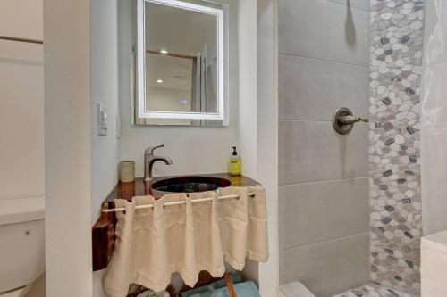 迪尔菲尔德海滩Garden Beach studio @The Island的浴室配有盥洗盆、淋浴和毛巾