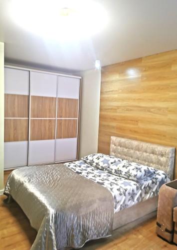 ShostkaSadovyy Bulʹvar 16的一间卧室设有一张床和木墙