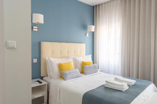 加亚新城Bella Gaia - Alojamento Local的卧室配有一张带黄色枕头的大型白色床。
