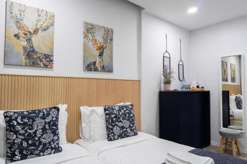 加亚新城Bella Gaia - Alojamento Local的卧室配有白色的床,墙上挂有绘画作品