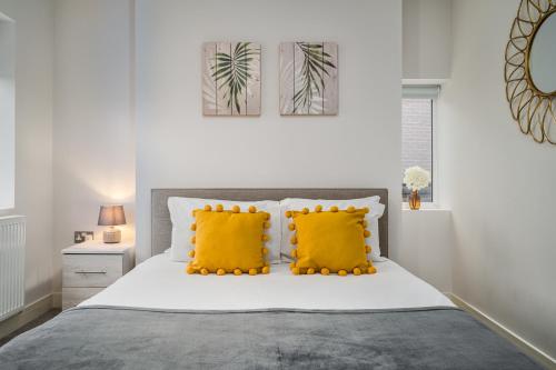 唐克斯特Coppergate Mews Apartment 4的一间卧室配有一张带两个黄色枕头的床