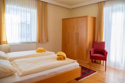 沃尔特湖畔佩莎赫孙布里克沃思特尔斯酒店的一间卧室配有两张床和红色椅子