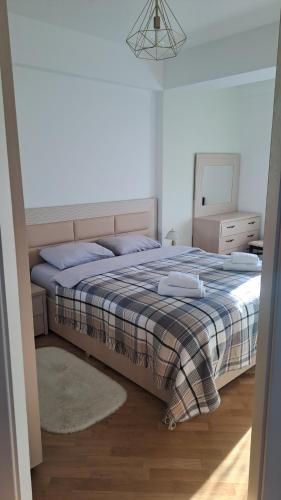 基希讷乌Аэропорт Апартаменты Комфорт的一间卧室配有一张带毯子和镜子的床
