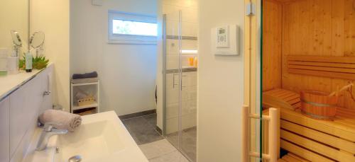 卡尔斯哈根Ferienwohnung Justus的带淋浴和白色盥洗盆的浴室