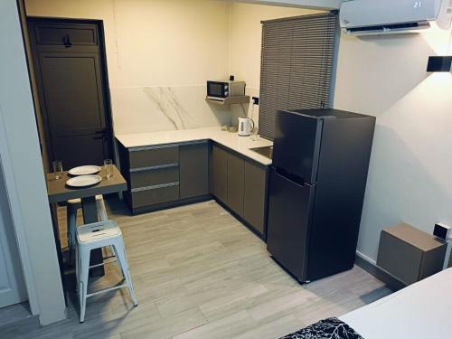 弗利康弗拉克VH Studios的一间小厨房,配有黑色冰箱和一张桌子